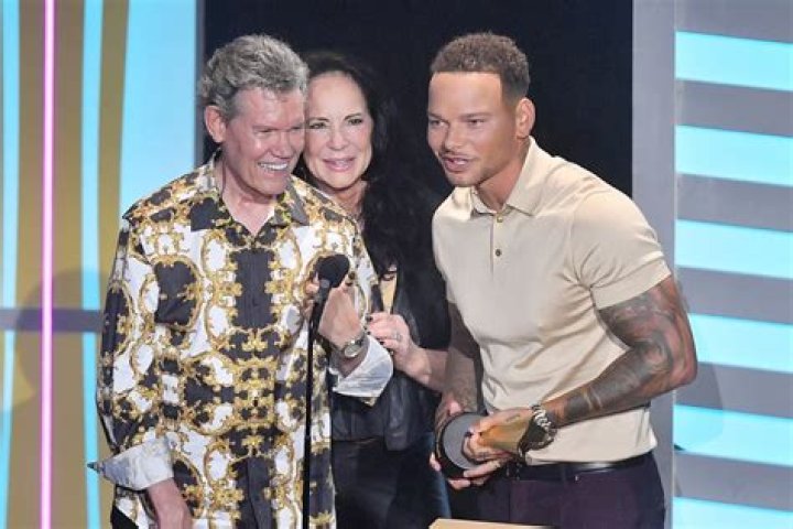 What was the age difference between Randy Travis and Lib Hatcher? ·